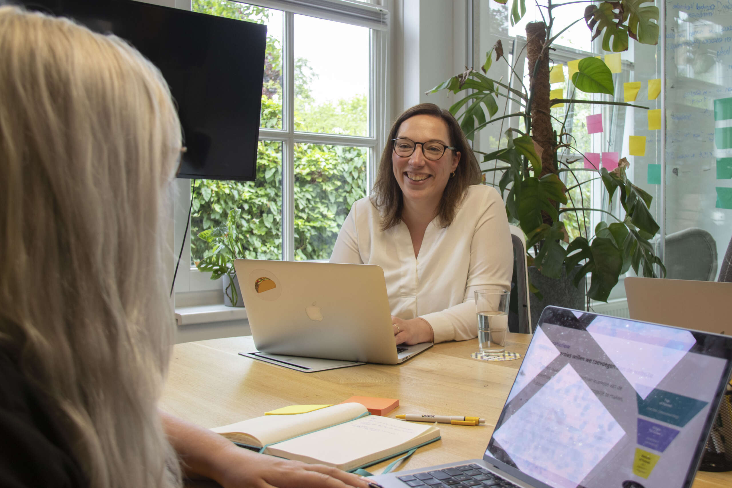 Petra aan de vergadertafel achter haar laptop