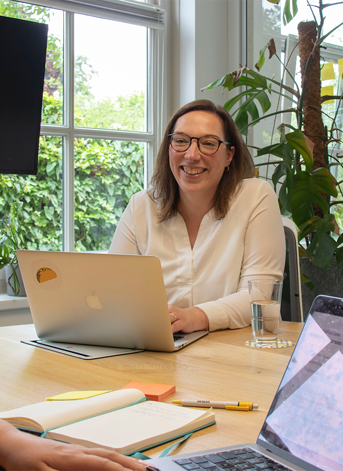 Petra achter laptop aan tafel