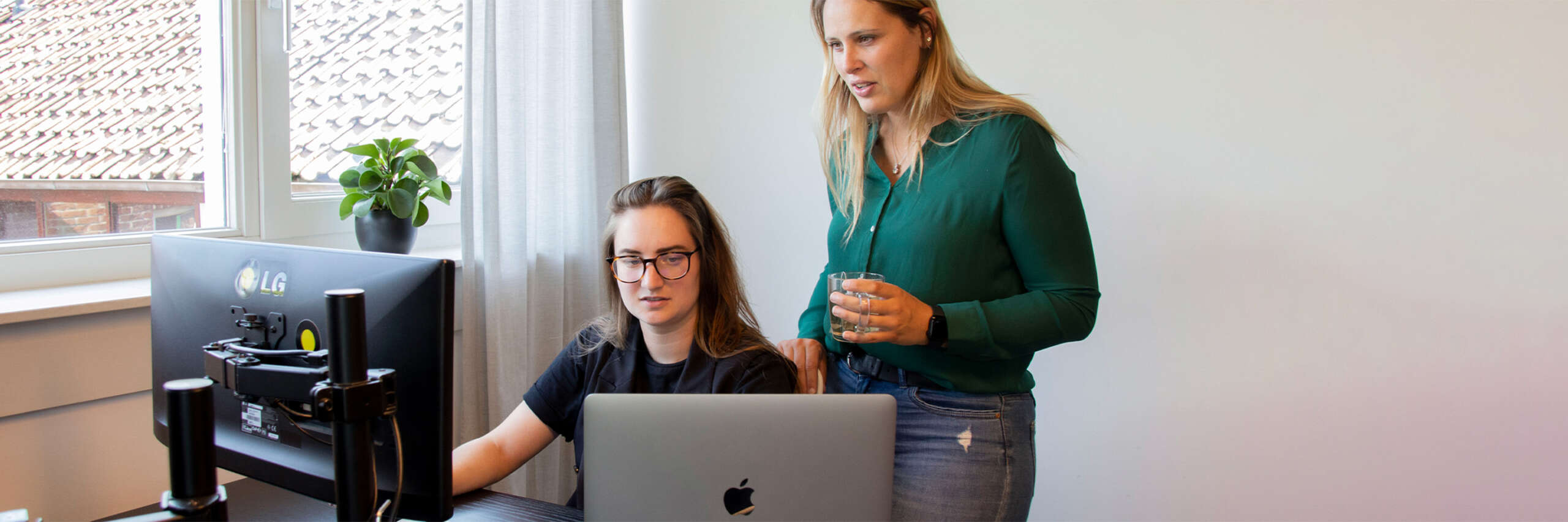 Cynthia en Sandra kijken naar het scherm