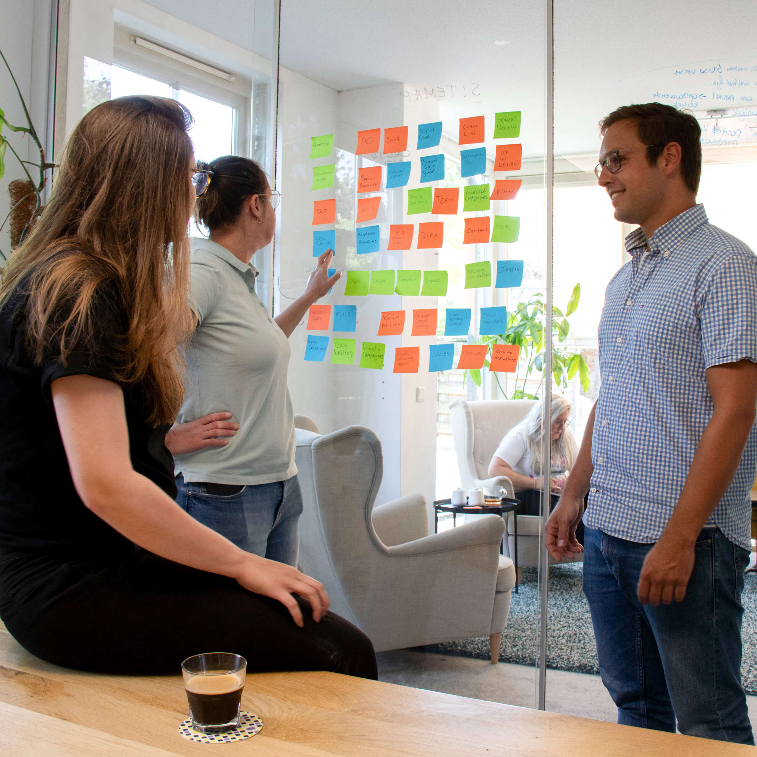Collega's Jorai Deijkers, Renate Leijser en Cynthia van Steenvelt aan het brainstormen met post-its.