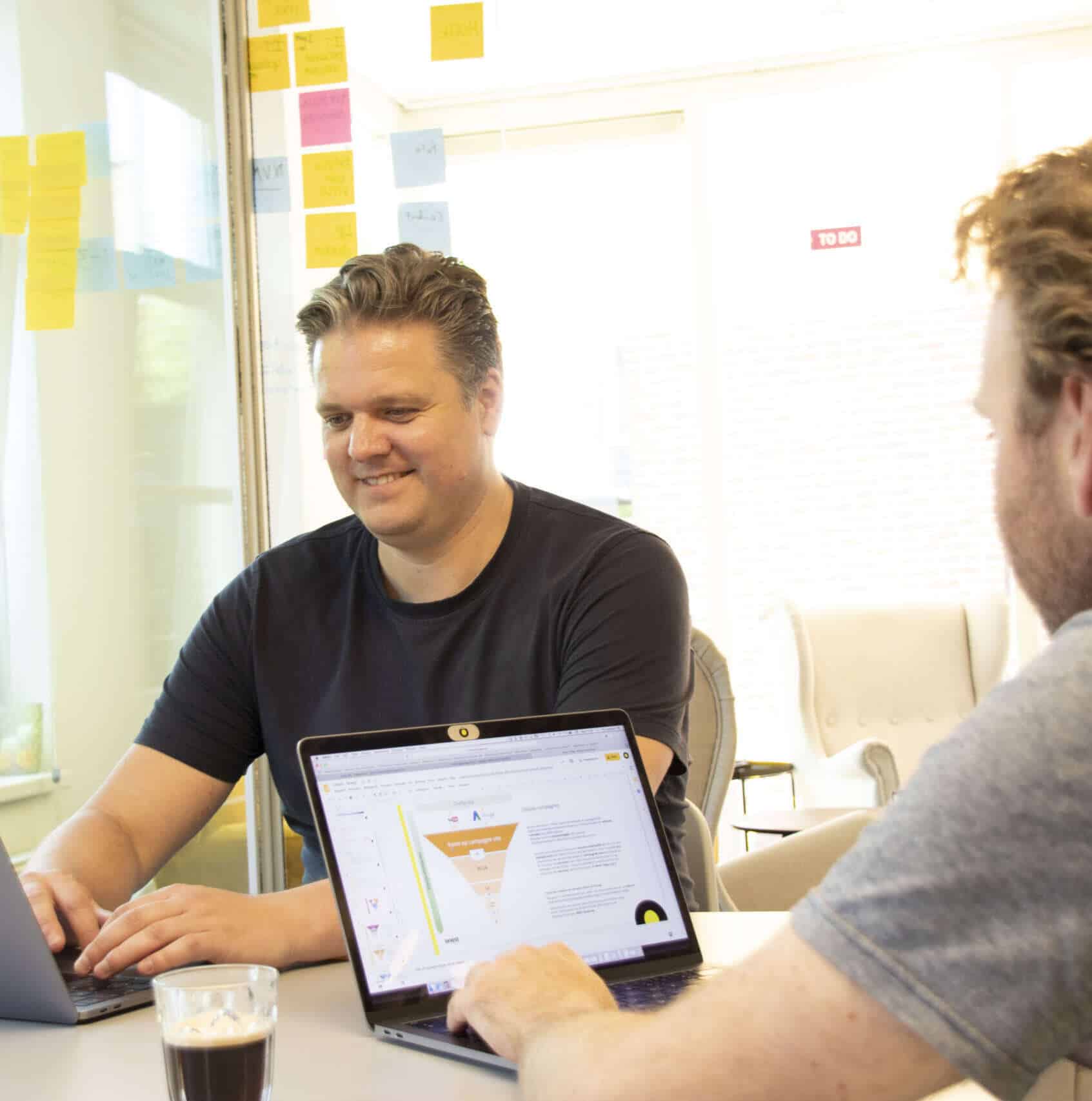 collega's achter laptop bespreken over marketing funnel