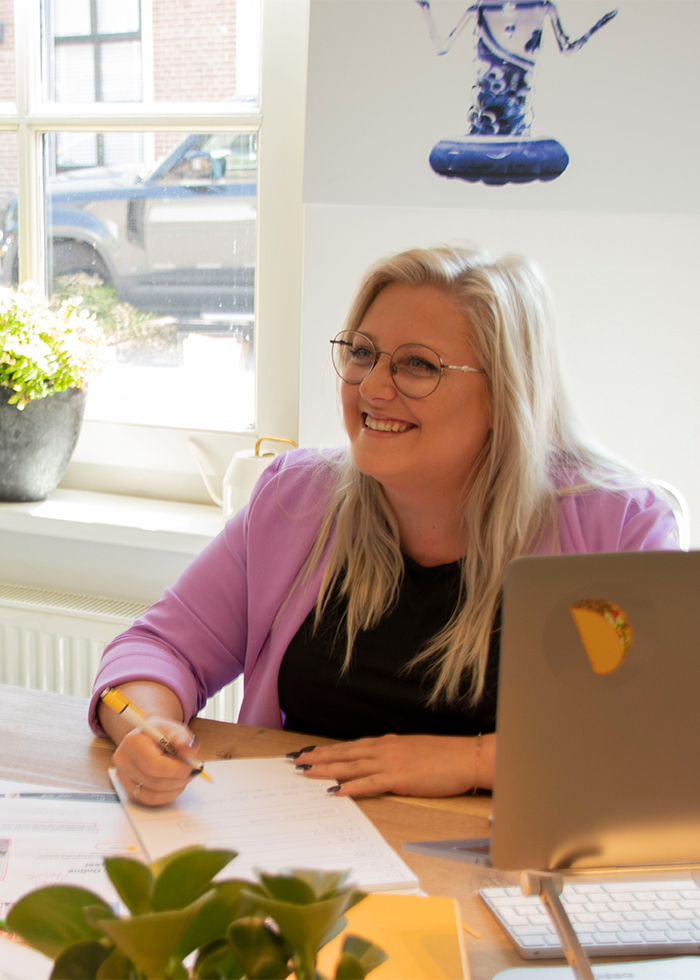 Kayleigh van Boxtel, scrum master, maakt lachend notities voor de aankomende retrospective in het Onest-kantoor.